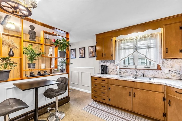 kitchen featuring a sink, light countertops, backsplash, and open shelves