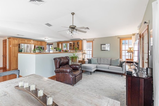 living room with lofted ceiling, plenty of natural light, and a ceiling fan