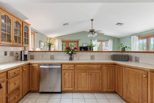 kitchen with dishwasher, vaulted ceiling, tasteful backsplash, ceiling fan, and plenty of natural light