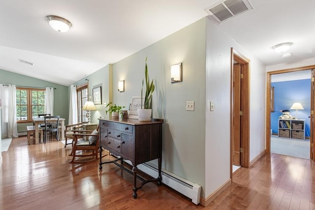 hall with wood-type flooring, vaulted ceiling, and baseboard heating