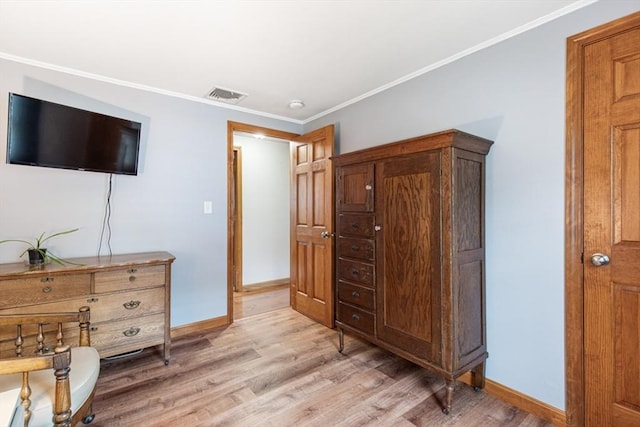 bedroom with light wood finished floors, baseboards, and crown molding