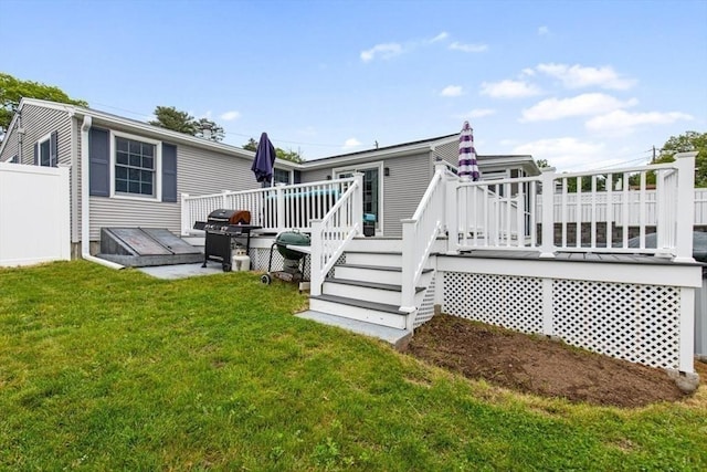 back of house with a deck and a yard