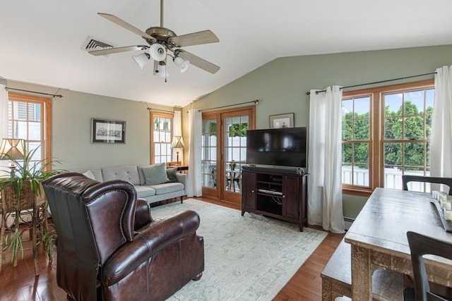 living area with lofted ceiling, ceiling fan, wood finished floors, french doors, and a baseboard heating unit