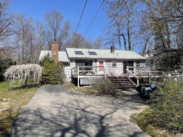 53 Beechwood St, Cohasset, MA 02025 - view of front of property with a chimney, a wooden deck, and asphalt driveway