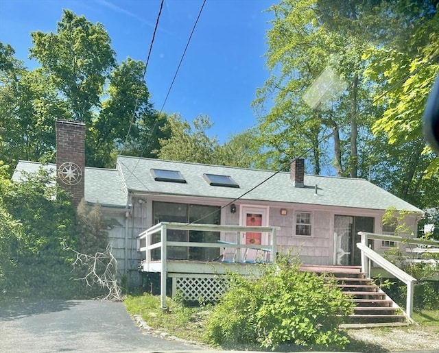 53 Beechwood St, Cohasset, MA 02025 - view of front facade with a chimney, a shingled roof, and a deck