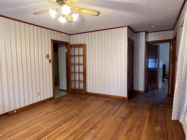 spare room with wood-type flooring, ornamental molding, and ceiling fan