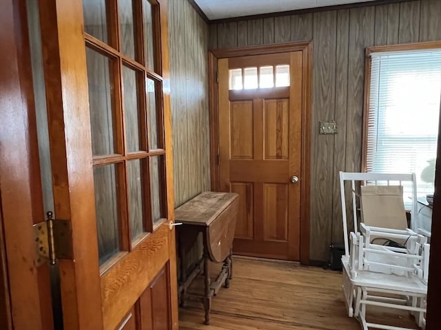 mudroom featuring light hardwood / wood-style flooring, a wealth of natural light, and wood walls