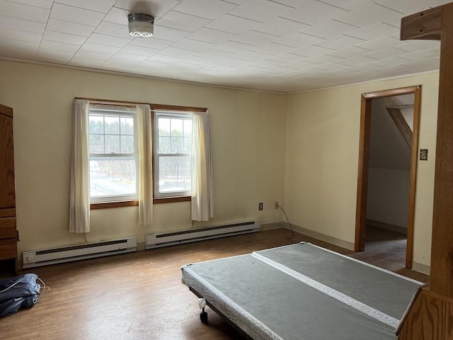 exercise room featuring dark wood-type flooring, a baseboard radiator, and ornamental molding