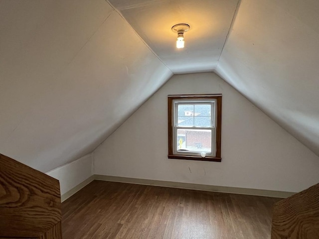 bonus room with vaulted ceiling and dark hardwood / wood-style flooring