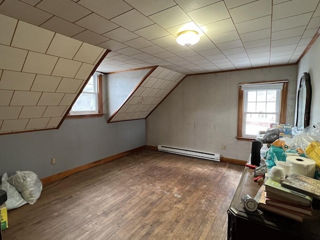 bonus room with a healthy amount of sunlight, vaulted ceiling, wood-type flooring, and a baseboard heating unit