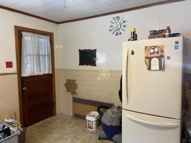 kitchen with crown molding, white fridge, radiator heating unit, and tile walls