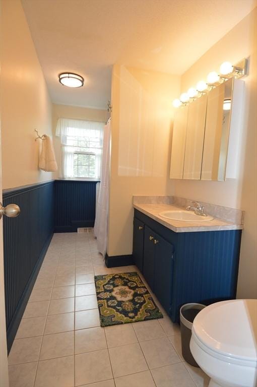 17 Bayberry Cir Unit 17, Millis, MA 02054 - bathroom with a wainscoted wall, tile patterned flooring, toilet, vanity, and a shower with curtain