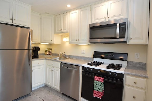 17 Bayberry Cir Unit 17, Millis, MA 02054 - kitchen featuring appliances with stainless steel finishes, a sink, white cabinetry, light tile patterned floors, and light countertops