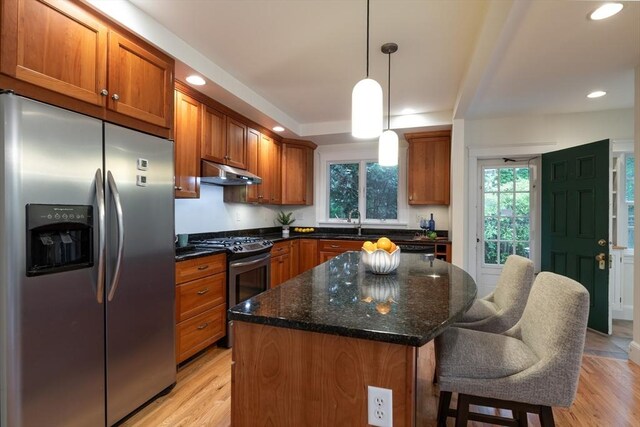 88 Round Hill Rd Unit 4, Northampton, MA 01060 - kitchen featuring stainless steel appliances, under cabinet range hood, light wood finished floors, brown cabinetry, and a center island