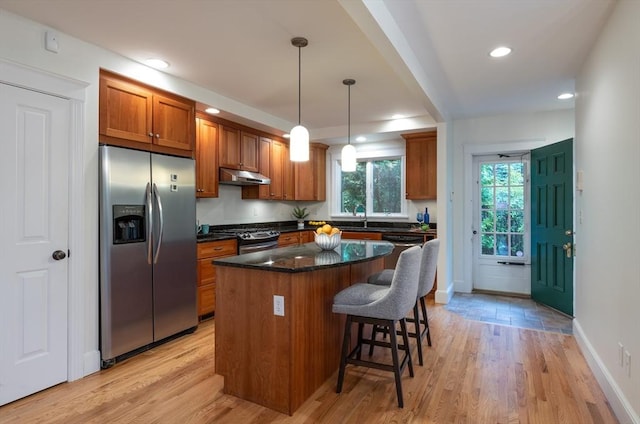 88 Round Hill Rd Unit 4, Northampton, MA 01060 - kitchen with appliances with stainless steel finishes, under cabinet range hood, brown cabinets, a kitchen island, and a sink