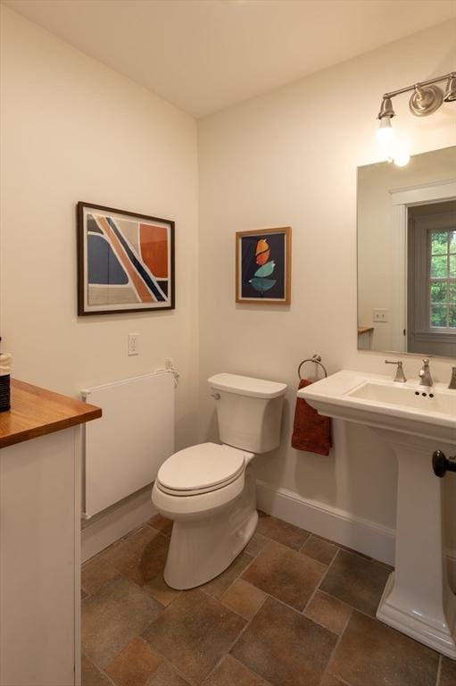 88 Round Hill Rd Unit 4, Northampton, MA 01060 - bathroom featuring baseboards, toilet, and stone finish flooring