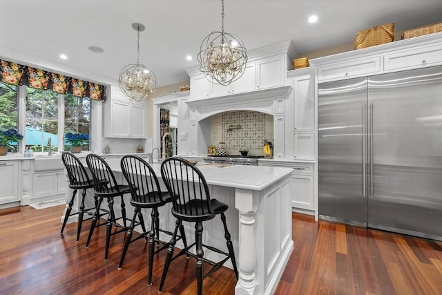 236 Grove St, Wellesley, MA 02482 - kitchen featuring built in refrigerator, a chandelier, light countertops, decorative backsplash, and white cabinetry