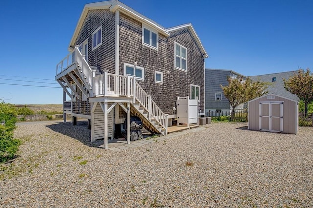 back of property featuring a storage shed, stairway, an outbuilding, and a wooden deck