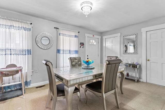 dining room with visible vents, baseboards, a healthy amount of sunlight, and light floors