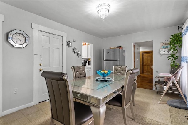 dining room with baseboards and light floors