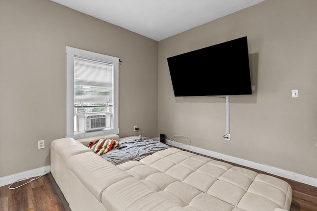 bedroom with wood finished floors, baseboards, and cooling unit