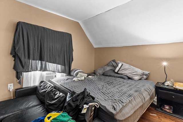 bedroom with wood finished floors, lofted ceiling, and cooling unit