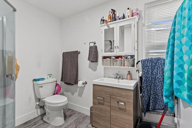 full bathroom with baseboards, wood finished floors, toilet, and vanity