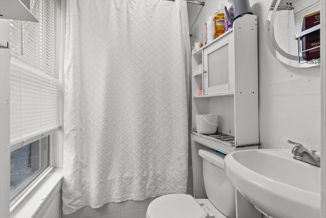 full bathroom with a sink, toilet, and a shower with curtain