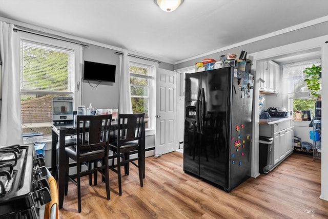 dining space featuring crown molding and light wood finished floors
