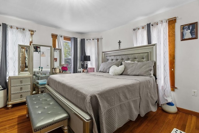 bedroom with baseboards and wood finished floors