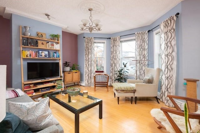 sitting room with an inviting chandelier, a textured ceiling, and wood finished floors