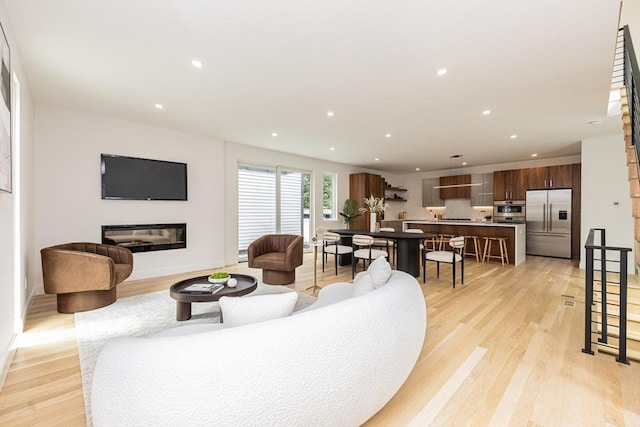 95 Griswold St Unit 95, Cambridge, MA 02139 - living room featuring light wood-style floors, recessed lighting, a glass covered fireplace, and baseboards