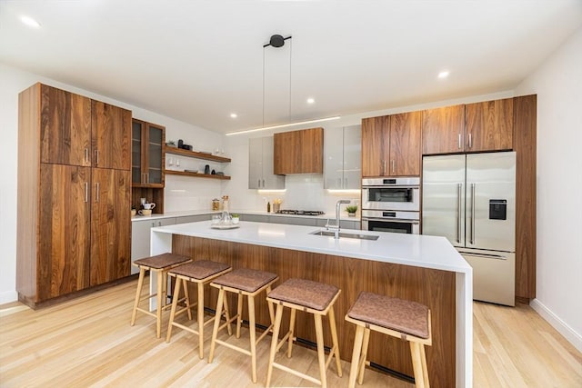 95 Griswold St Unit 95, Cambridge, MA 02139 - kitchen with appliances with stainless steel finishes, a sink, light wood-style floors, a breakfast bar, and recessed lighting