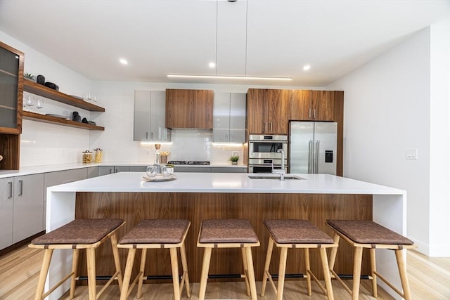 95 Griswold St Unit 95, Cambridge, MA 02139 - kitchen featuring stainless steel appliances, light wood-style flooring, tasteful backsplash, light countertops, and recessed lighting