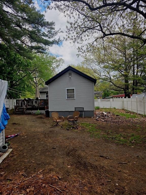 back of property featuring a deck and fence