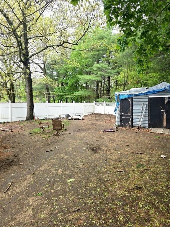 view of yard featuring fence, an outbuilding, and a storage shed