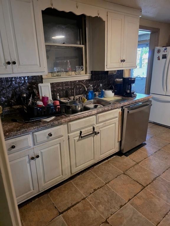 kitchen with freestanding refrigerator, dishwasher, a sink, and backsplash