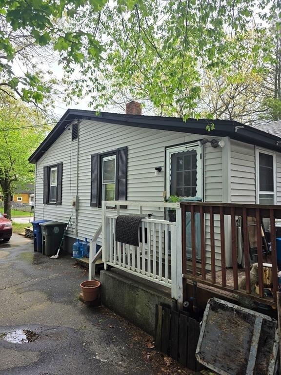 view of front of property featuring a chimney and a wooden deck