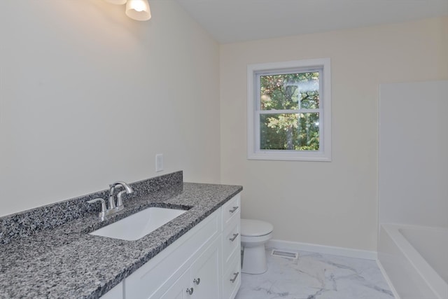 bathroom featuring a tub to relax in, vanity, and toilet