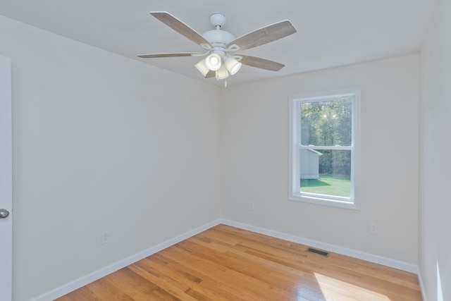 empty room with ceiling fan and light hardwood / wood-style flooring