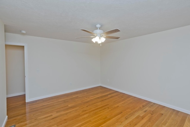 unfurnished room featuring light wood-type flooring, ceiling fan, and a textured ceiling