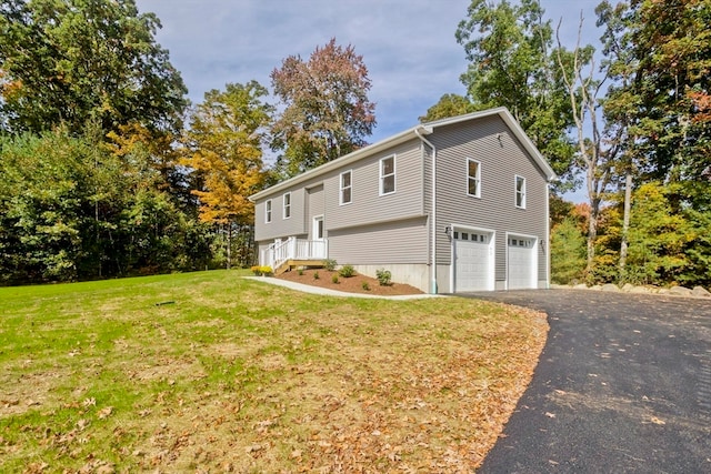 view of side of property with a yard and a garage