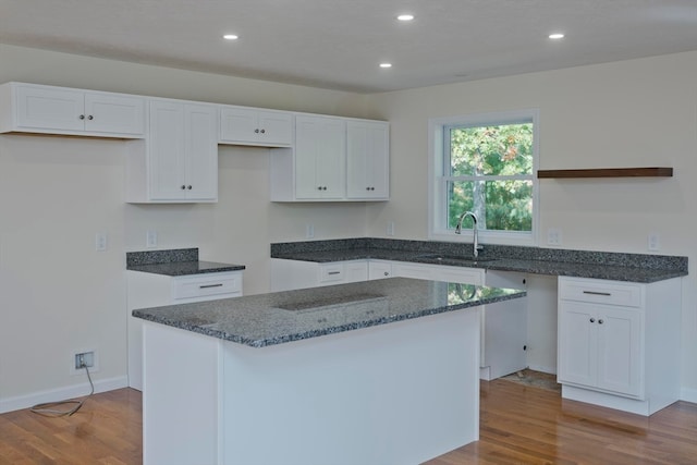 kitchen with white cabinetry, a center island, and sink