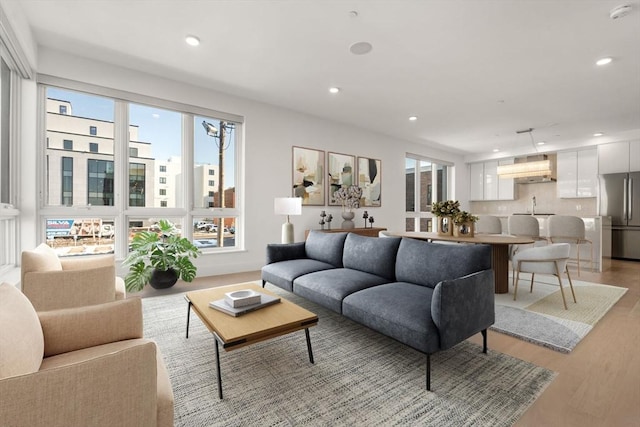 living area with recessed lighting and light wood-style floors