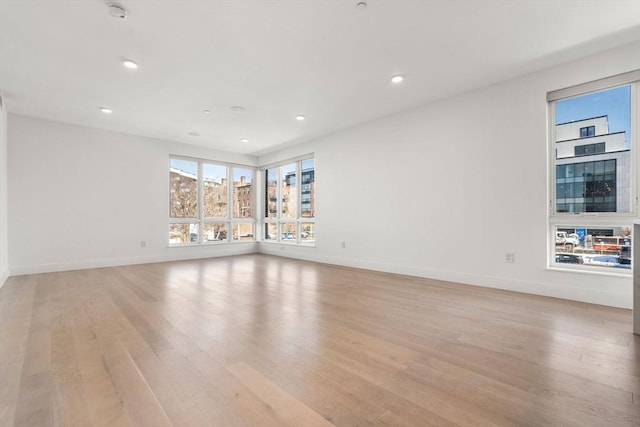 spare room featuring baseboards, light wood finished floors, and recessed lighting