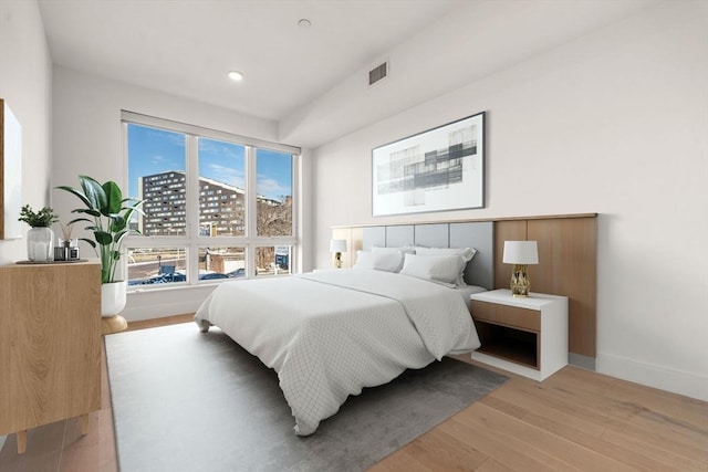 bedroom with light wood finished floors, baseboards, visible vents, and recessed lighting