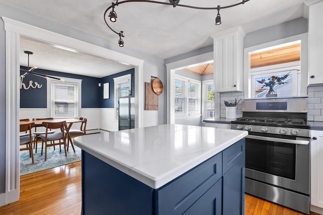 10 Saunders Rd, Lynn, MA 01904 - kitchen with gas range, decorative backsplash, blue cabinets, white cabinets, and light wood-style floors