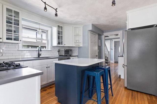 10 Saunders Rd, Lynn, MA 01904 - kitchen featuring stainless steel appliances, a kitchen island, a kitchen breakfast bar, decorative backsplash, and white cabinets