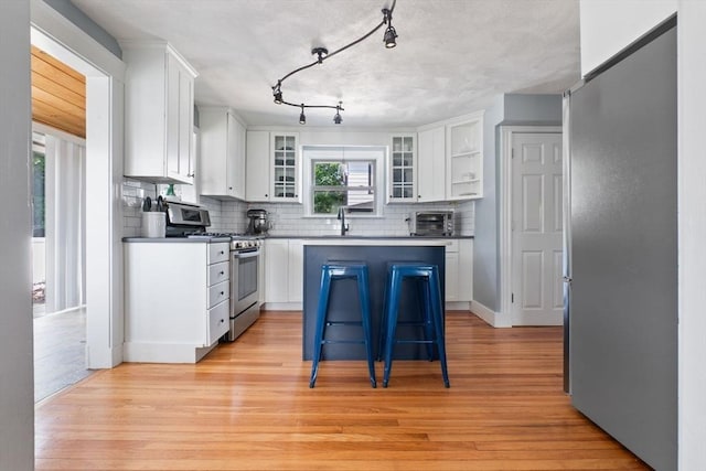 10 Saunders Rd, Lynn, MA 01904 - kitchen with stainless steel appliances, backsplash, white cabinets, and light wood-type flooring
