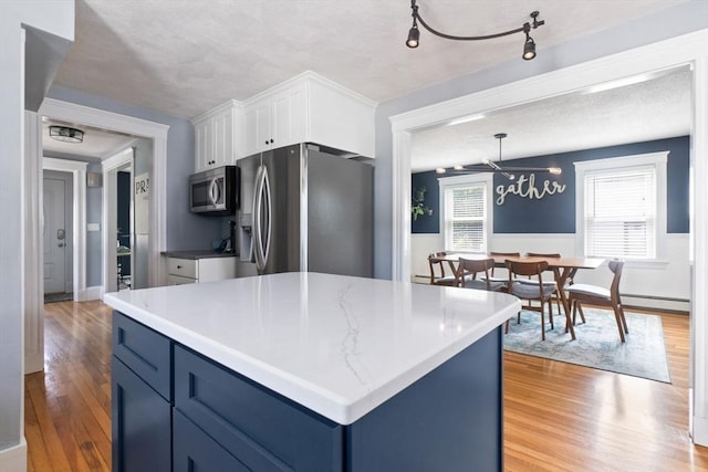 10 Saunders Rd, Lynn, MA 01904 - kitchen featuring stainless steel appliances, light wood-style floors, white cabinetry, blue cabinets, and a chandelier